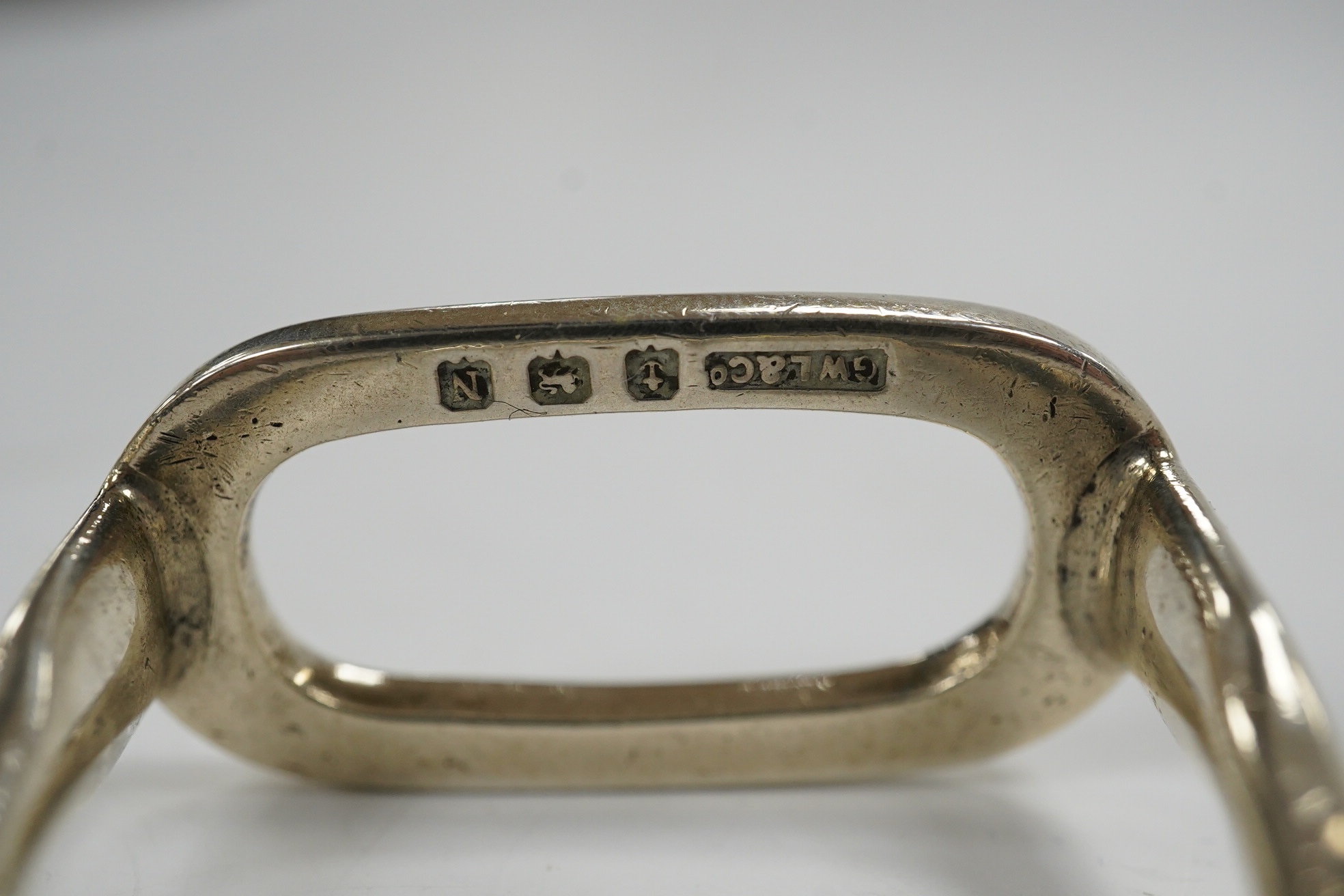 A George VI silver napkin ring modelled as a stirrup, surmounted with a fox, Birmingham, 1937, 46mm, together with a later silver horses head snuff box and a silver pill box with fox surmount. Condition - fair to good